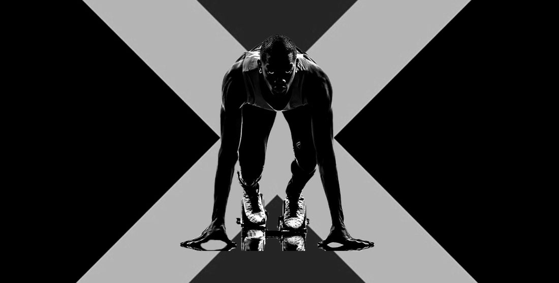 Nev custom wear- black and white image of sprinter in starting blocks.
